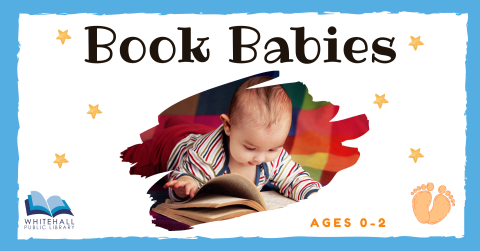 A baby looks at an open book